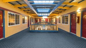 A hallway with a central wooden bench, red doors, and a skylight. - Town House Motel – Historic Old Town Eureka (Eureka)