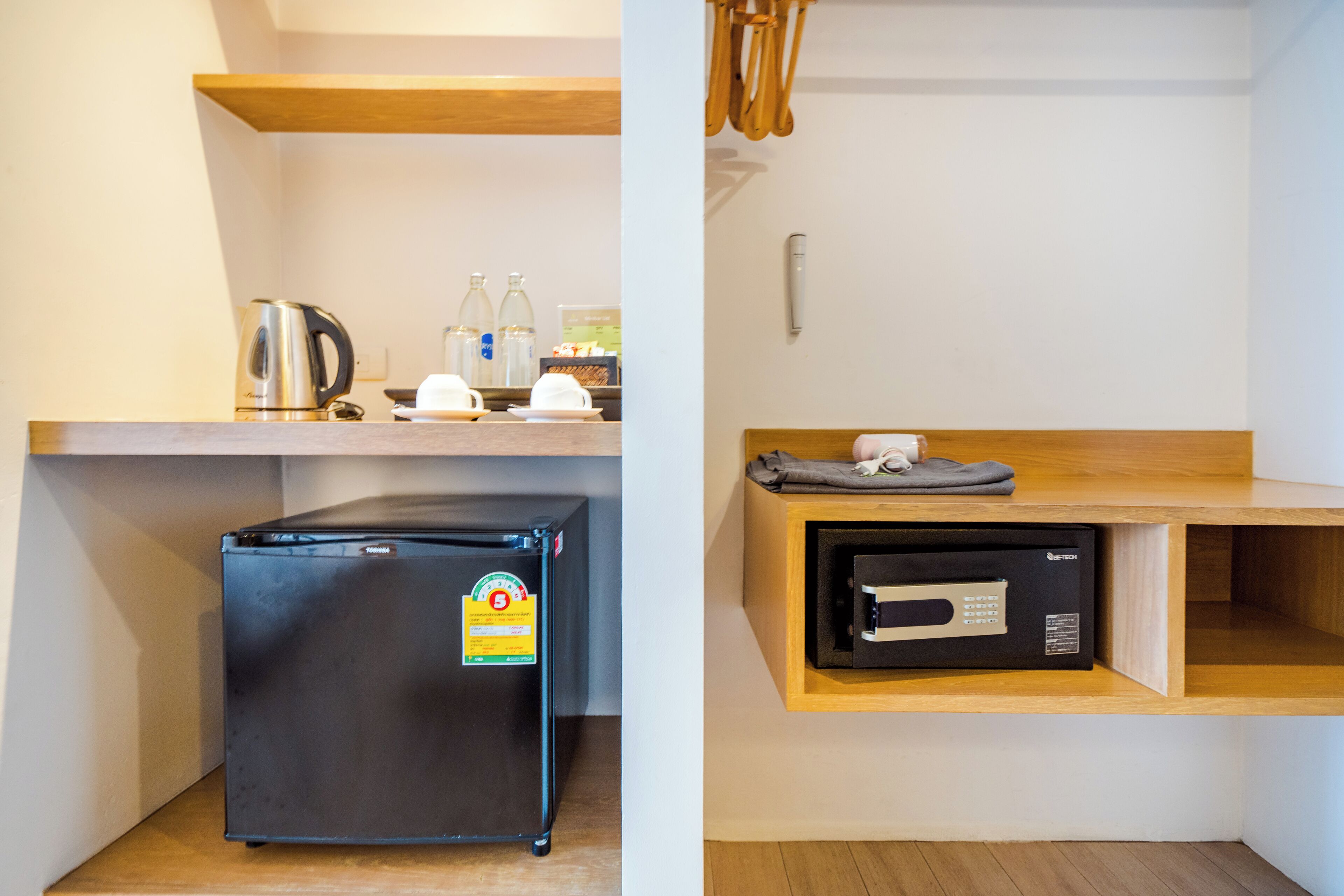 A compact kitchenette with a refrigerator, a coffee maker, and a microwave.