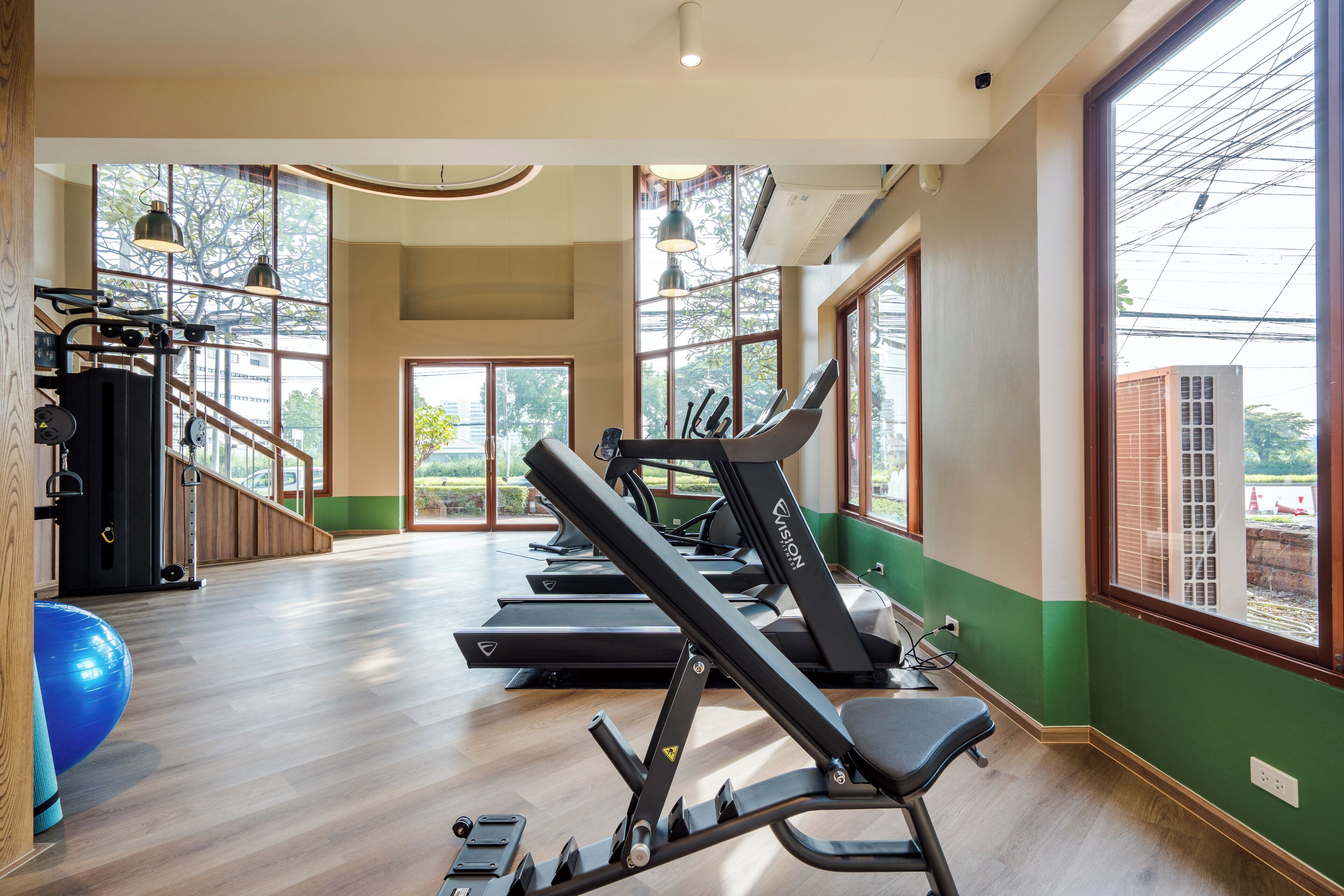 Ett gym med löpband, träningsbollar och styrketräningsmaskiner.