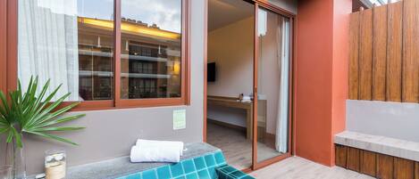 Un baño moderno con cabina de ducha de vidrio, un banco de madera y una planta en maceta.