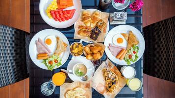 Un bufé de desayuno con diversos platos y bebidas sobre una mesa.