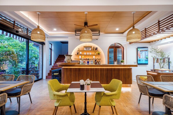 A restaurant with a wooden ceiling, wicker chairs, and a bar area with a sign reading "The Cat". - Ayrest Hotel (Hua Hin)