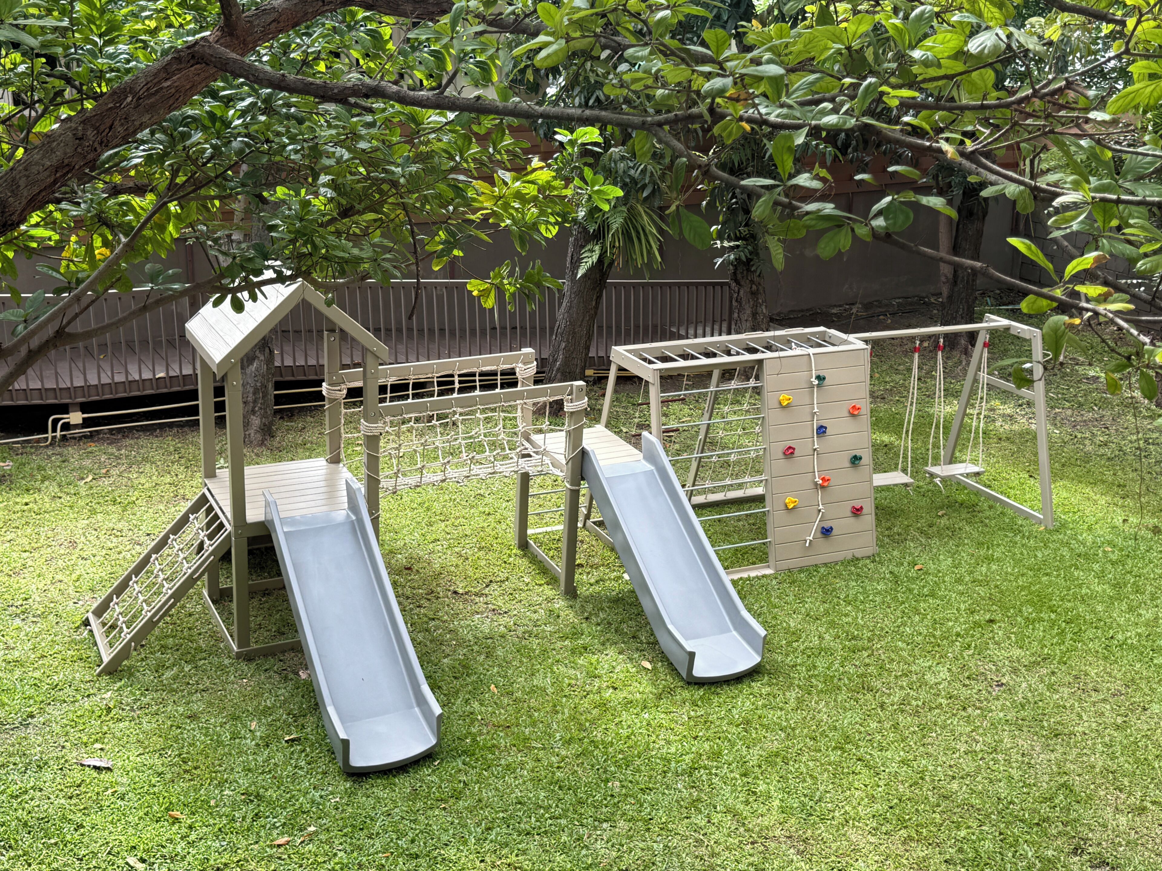A playground with two slides and a climbing structure.