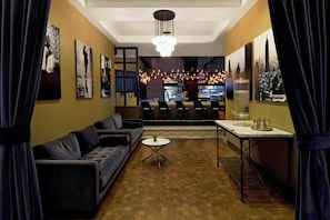 Uma área de estar moderna com um sofá, uma mesa redonda pequena e um espaço bar com balcão e cadeiras.
