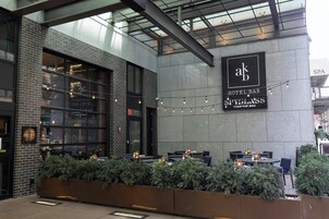 A hotel bar with outdoor seating, a visible sign for 'Hotel Bar Spyglass Rooftop Bar', and a brick facade.