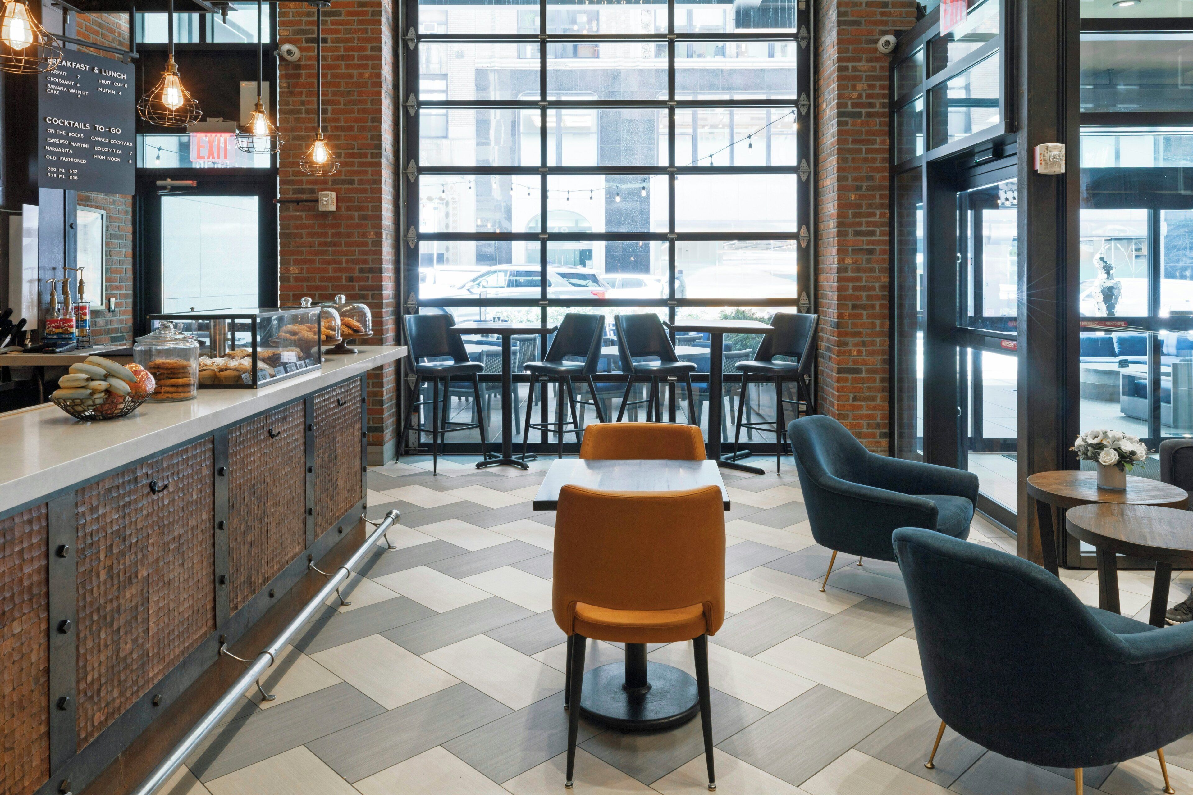 A cafe with a brick wall, a menu board, and a view of the street.