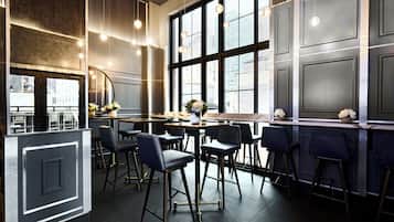 A modern bar area with high ceilings, large windows, and bar stools.