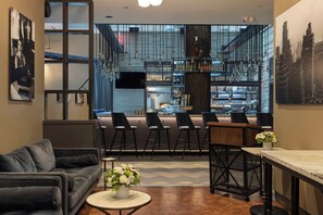 Un bar moderno con una distribución de asientos, una barra y vistas a la ciudad.