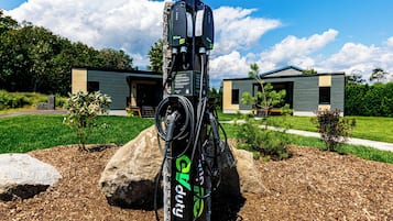 An electric vehicle charging station with a modern building in the background.