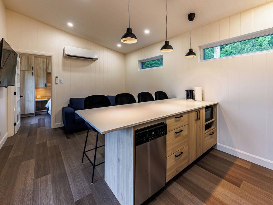 A modern kitchen with a central island, built-in appliances, and pendant lighting.
