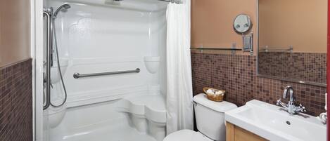 A bathroom with a walk-in shower, toilet, and sink.