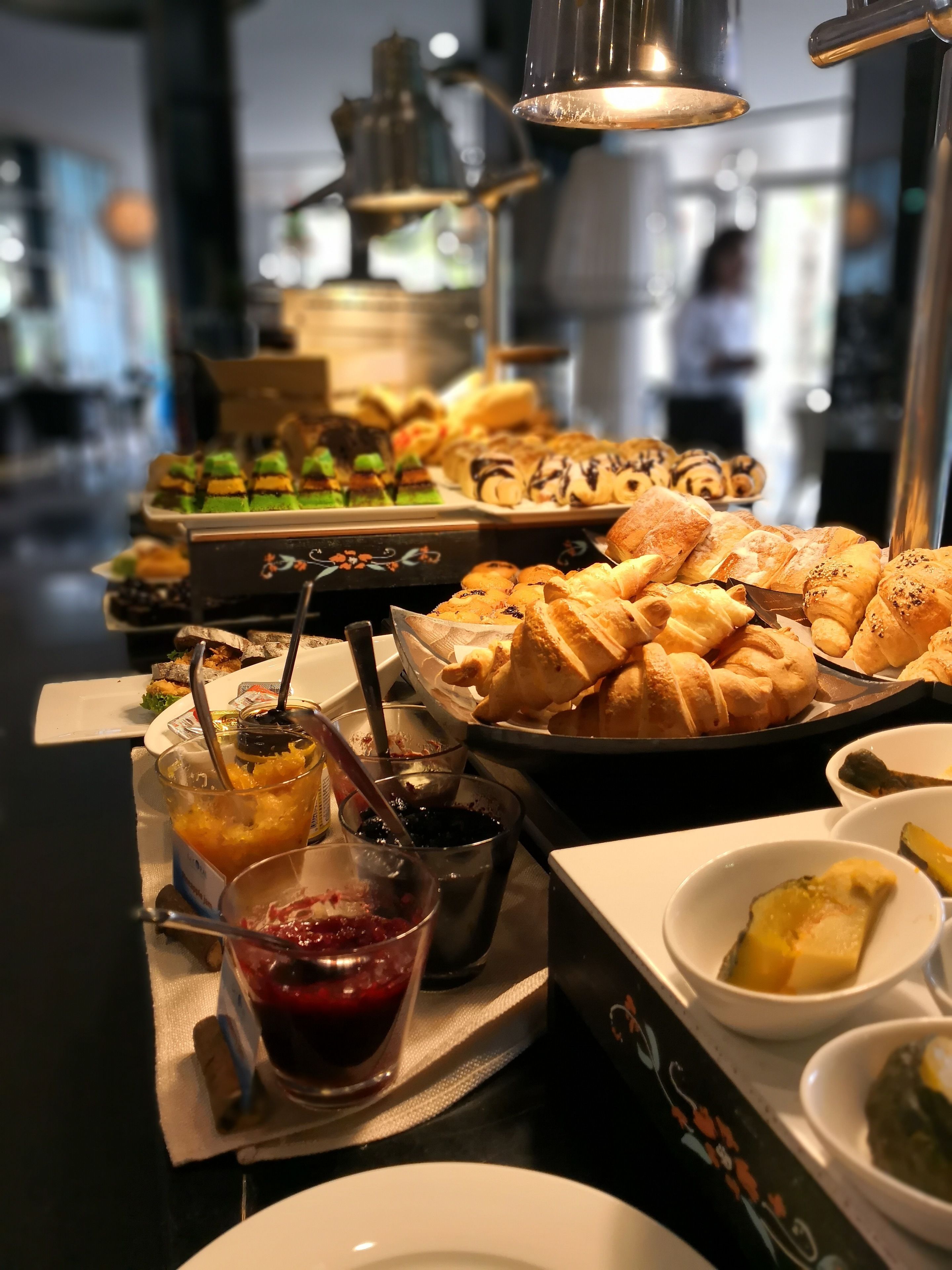 Una mesa de buffet con diversos pasteles, postres y salsas.