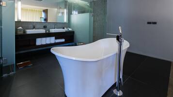 Une salle de bain moderne avec une baignoire sur pieds, deux vasques et un grand miroir.