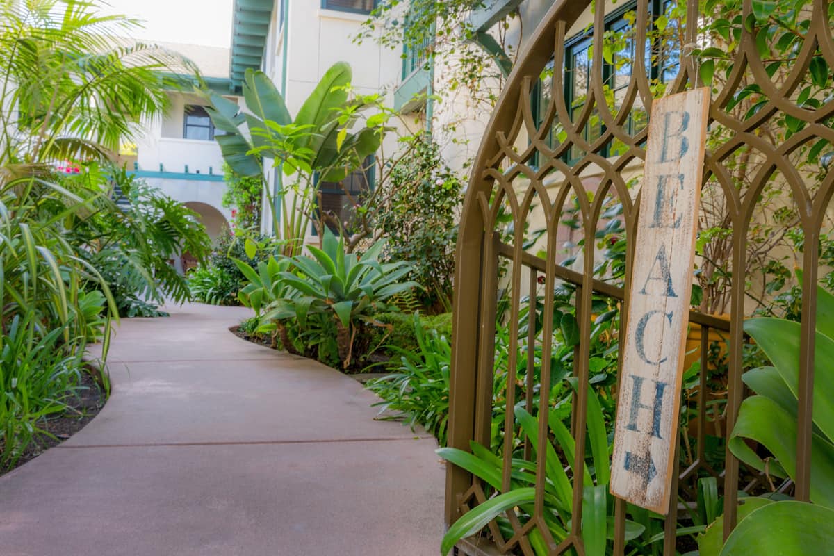 A pathway leading to a gated area with a sign reading "BEACH".