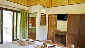 A hotel room with a bed, a wooden wardrobe, a mirror, and a desk. - Manita Resort (Koh Samui)