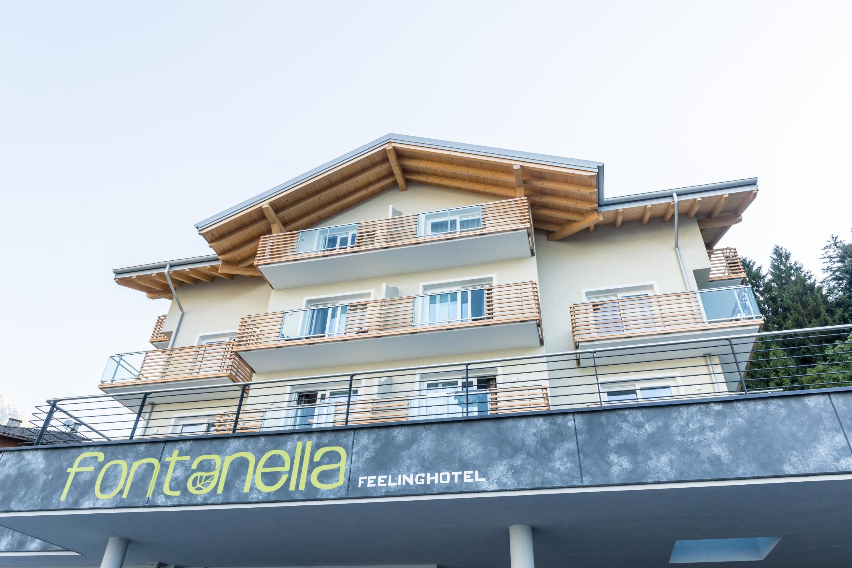 Un edificio hotel con diversi piani, balconi e un cartello che riporta la scritta "Fontanella Feelinghotel".