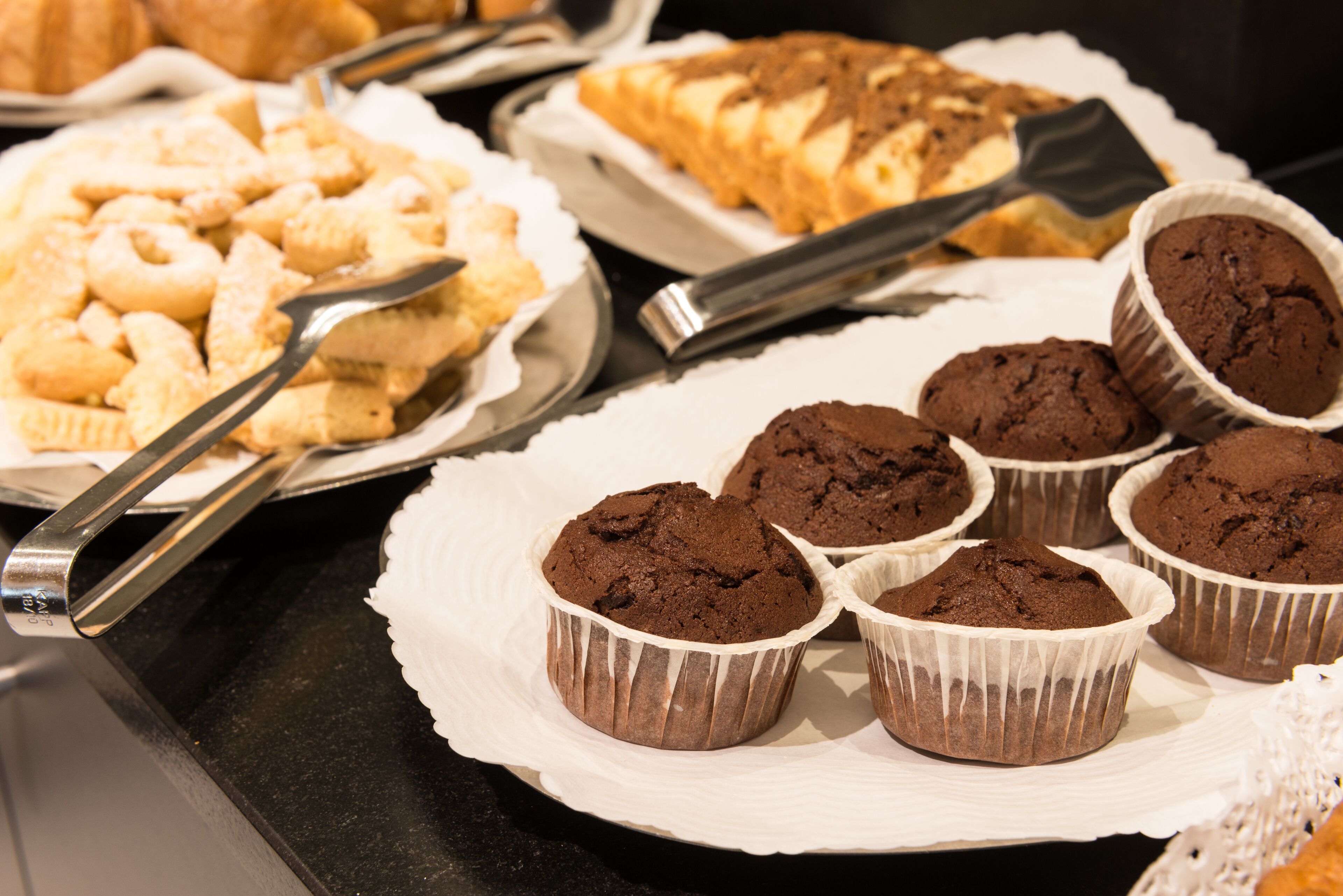 Diverse gebakjes te zien, waaronder koekjes en muffins.