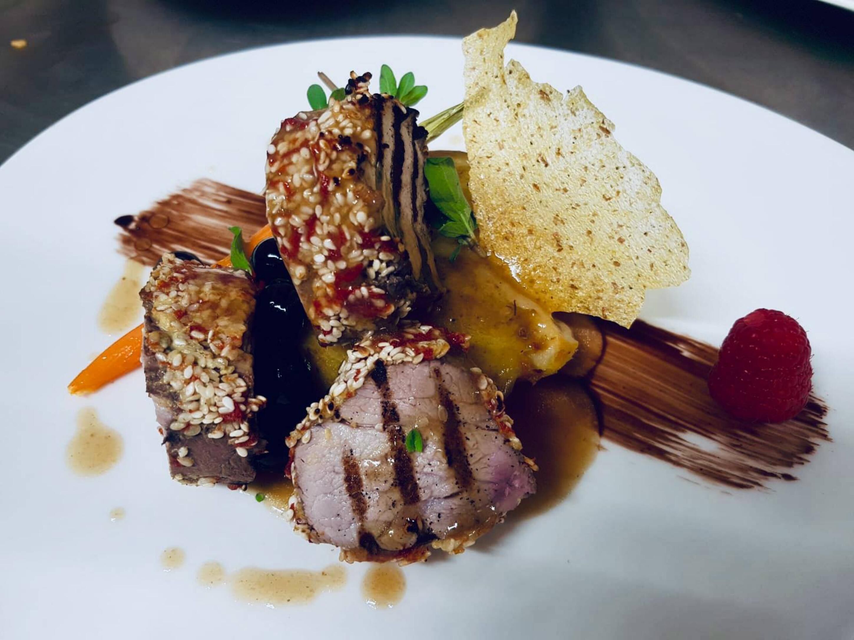 Prato de comida com diversos pratos, incluindo um pedaço de carne, uma fatia de pão e uma fruta.