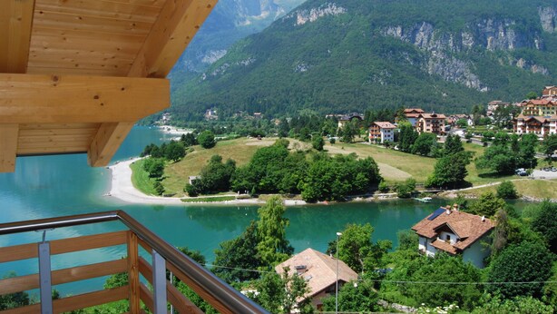A wooden balcony overlooking a lake with a mountain backdrop. - Feeling Hotel Fontanella (Molveno)