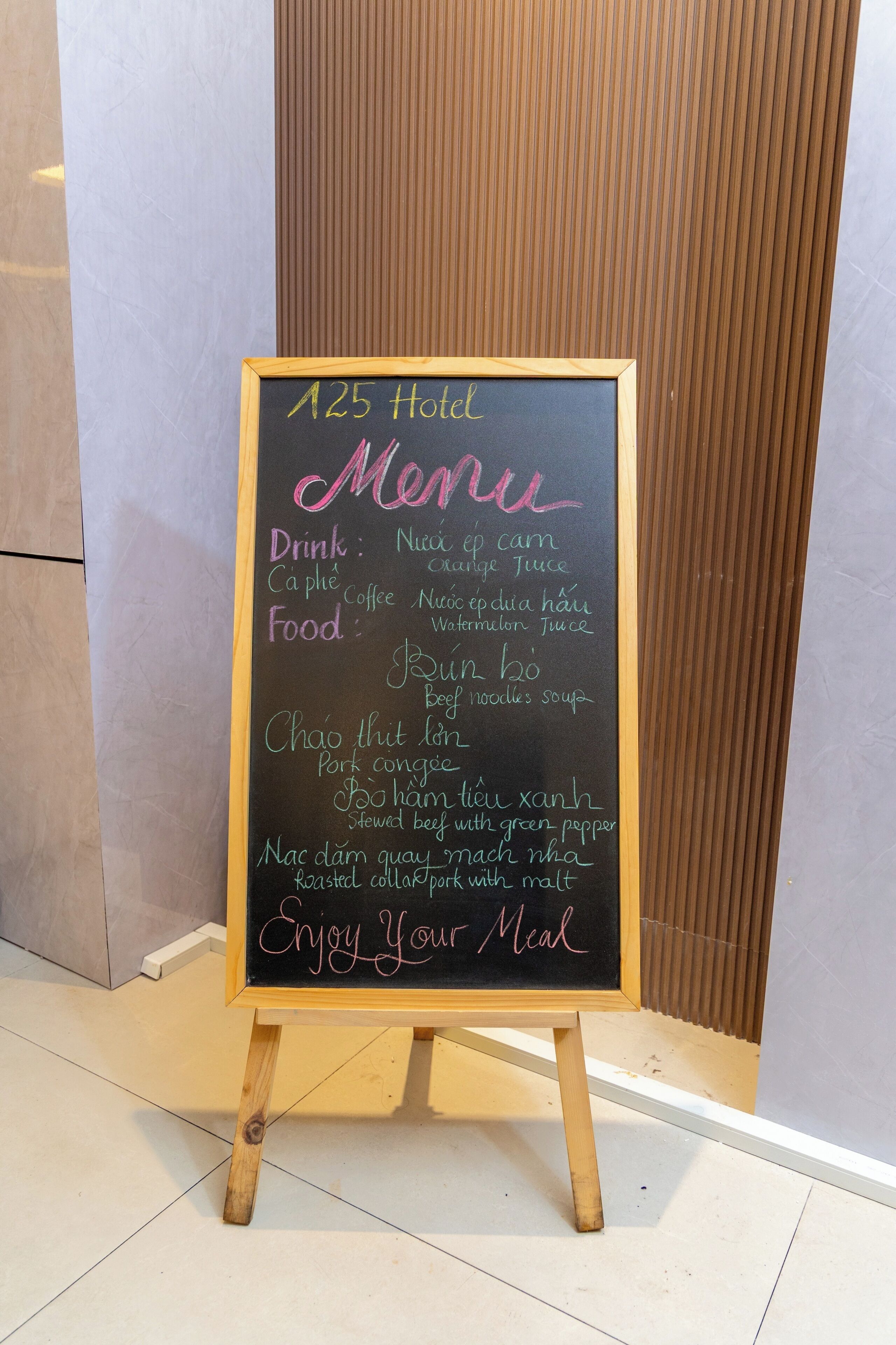 A chalkboard menu stand with a list of drinks and food items at 125 Hotel.