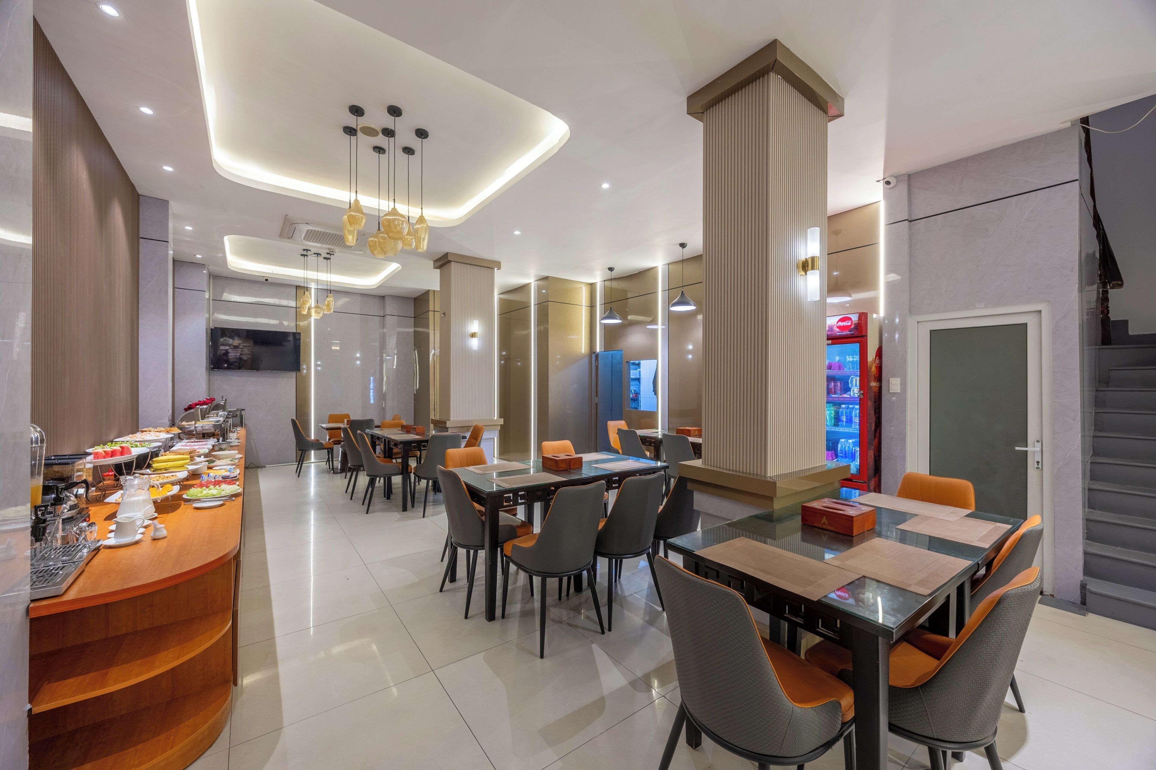 Un comedor moderno con bufé, varias mesas y una escalera.