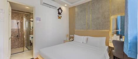 Une chambre d’hôtel avec un grand lit, un bureau avec une chaise, un espace douche et une horloge au mur.