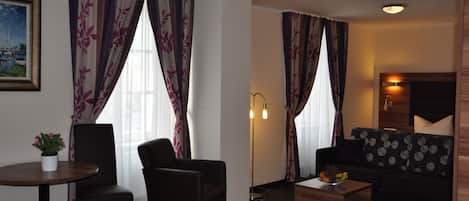 A modern living room with a sofa, two armchairs, a coffee table, and a floor lamp.