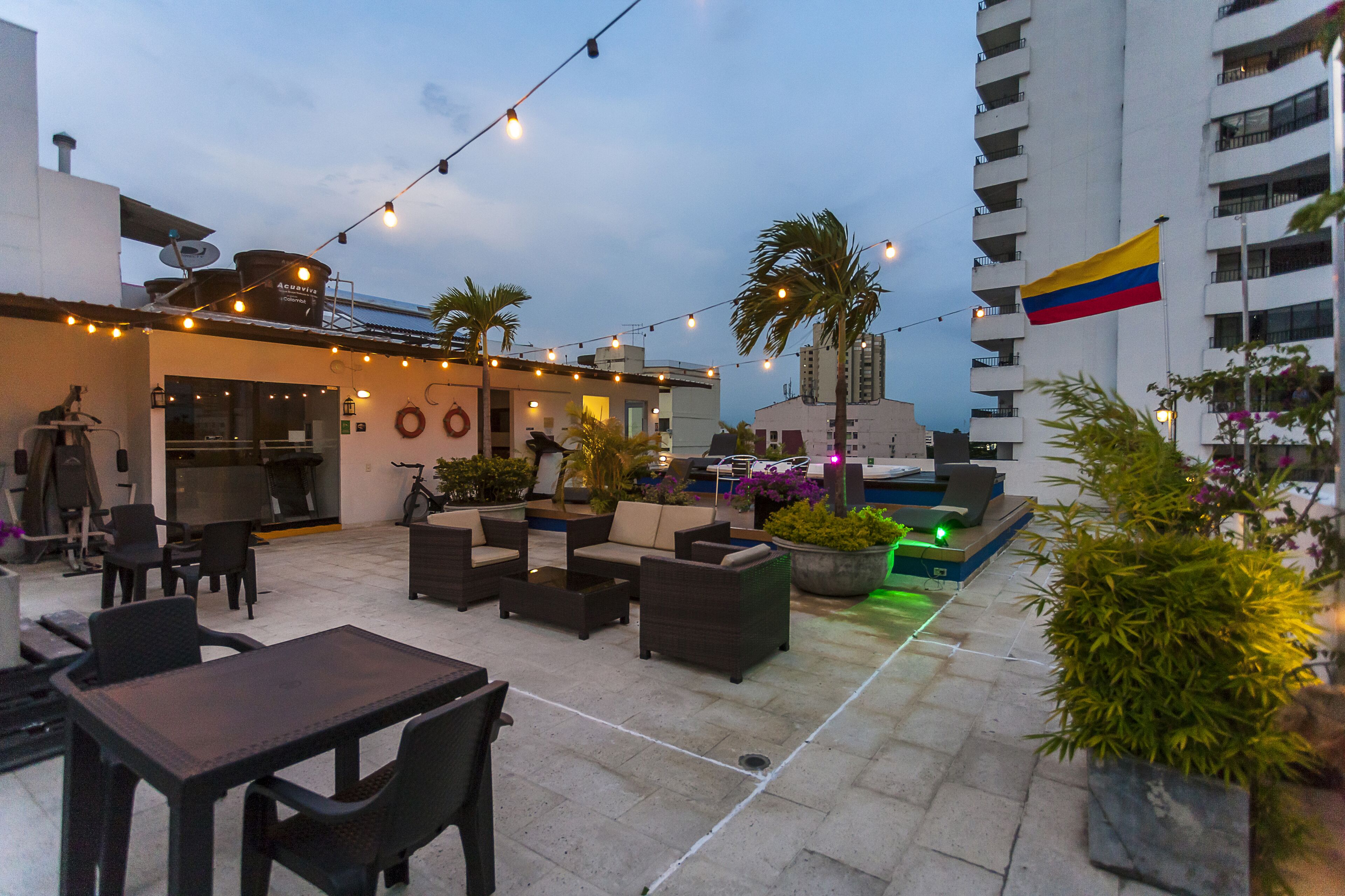 An outdoor patio area with seating, a dining table, and string lights.