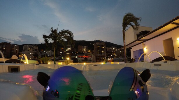 A pair of sunglasses on a pool deck with a cityscape in the background. - Aqua Granada Hotel (Cali)