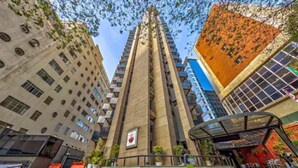 A modern high-rise building with a unique architectural design, featuring a central tower and multiple smaller structures around it. - Hotel Massis (São Paulo)
