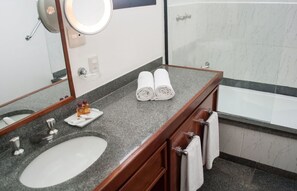 Een bad/douchecombinatie, een haardroger, handdoeken