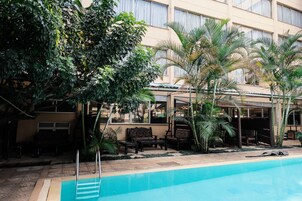 Una piscina al aire libre, sillones reclinables de piscina