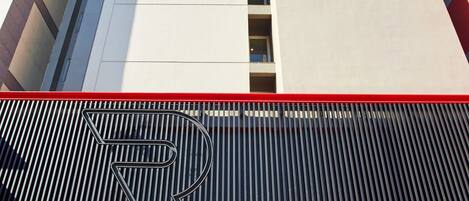 A Red Planet Hotels building with a modern facade, large windows, and a prominent red sign.