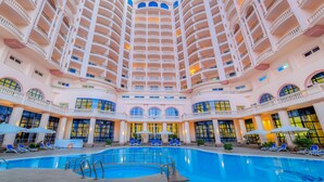 A multi-story hotel with a central swimming pool, balconies on each floor, and large windows. - Tolip Alexandria (Alexandria)