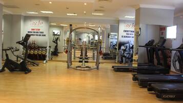 A gym with cardio machines, weight equipment, and mirrors.