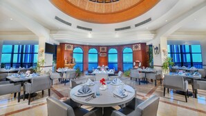 A spacious dining area with round tables, large windows, and a decorative ceiling. - Tolip Alexandria (Alexandria)
