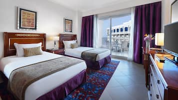 Habitación de hotel con dos camas, un balcón con vistas y un televisor en una cómoda.