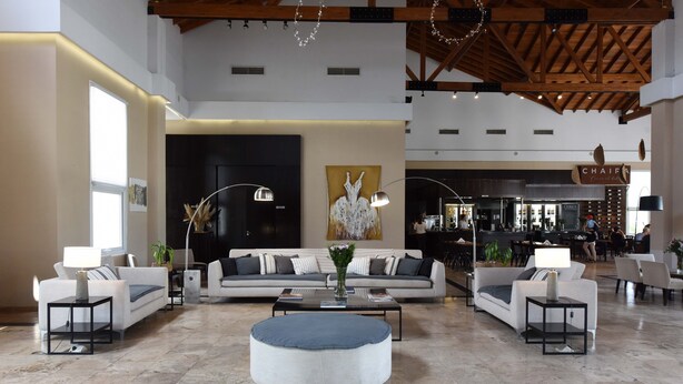 A spacious lobby with a modern design, featuring a large sofa set, a round ottoman, and a coffee table. - Howard Johnson by Wyndham Ezeiza Convention Center (Tristan Suarez)