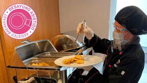 A buffet setup with a person serving nachos. - Hotel MX garibaldi CDMX, Trademark Collection by Wyndham (Mexico City)