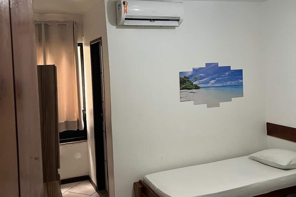 Ein Zimmer mit einem Bett, einem Schreibtisch und einer Klimaanlage.