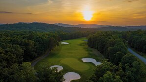 An aerial view of a golf course surrounded by dense forest and hills. - The Resort at Glade Springs (Daniels)