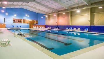 Swimmers can enjoy a long, rectangular pool surrounded by a tiled deck and lounge chairs.