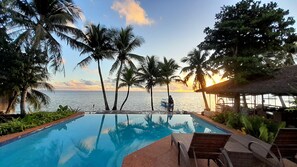 A swimming pool with a view of the sea and palm trees. - Romantic Beach Villas Siargao Island (General Luna)