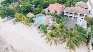A resort with a swimming pool, palm trees, and a beach. - Panglao Pearl Premier White Sand Resort (Panglao)