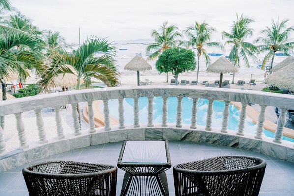 A poolside area with a marble balustrade, wicker chairs, and a view of the beach. - Panglao Pearl Premier White Sand Resort (Panglao)