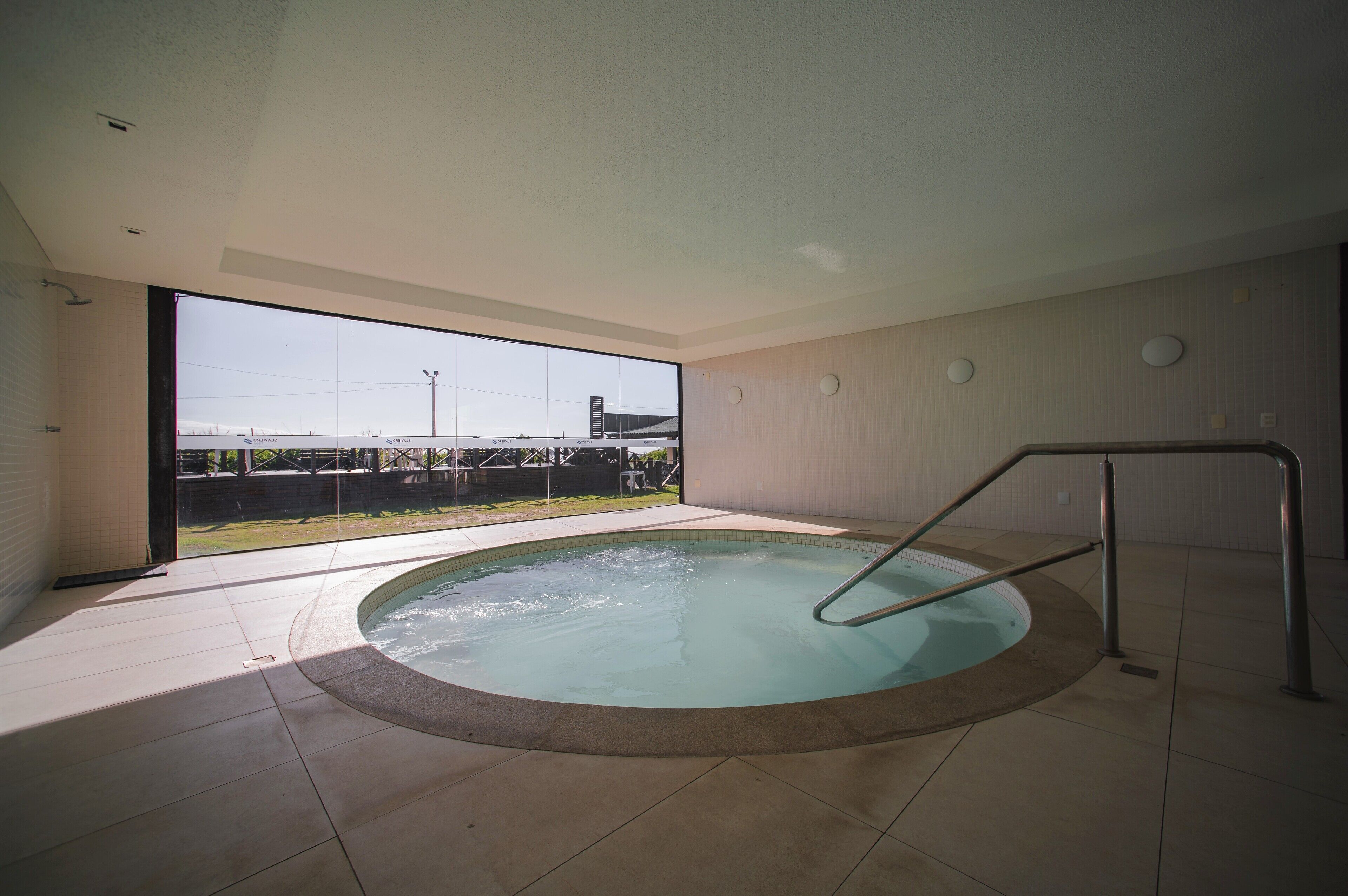 A modern indoor swimming pool with a clear view of the outside.