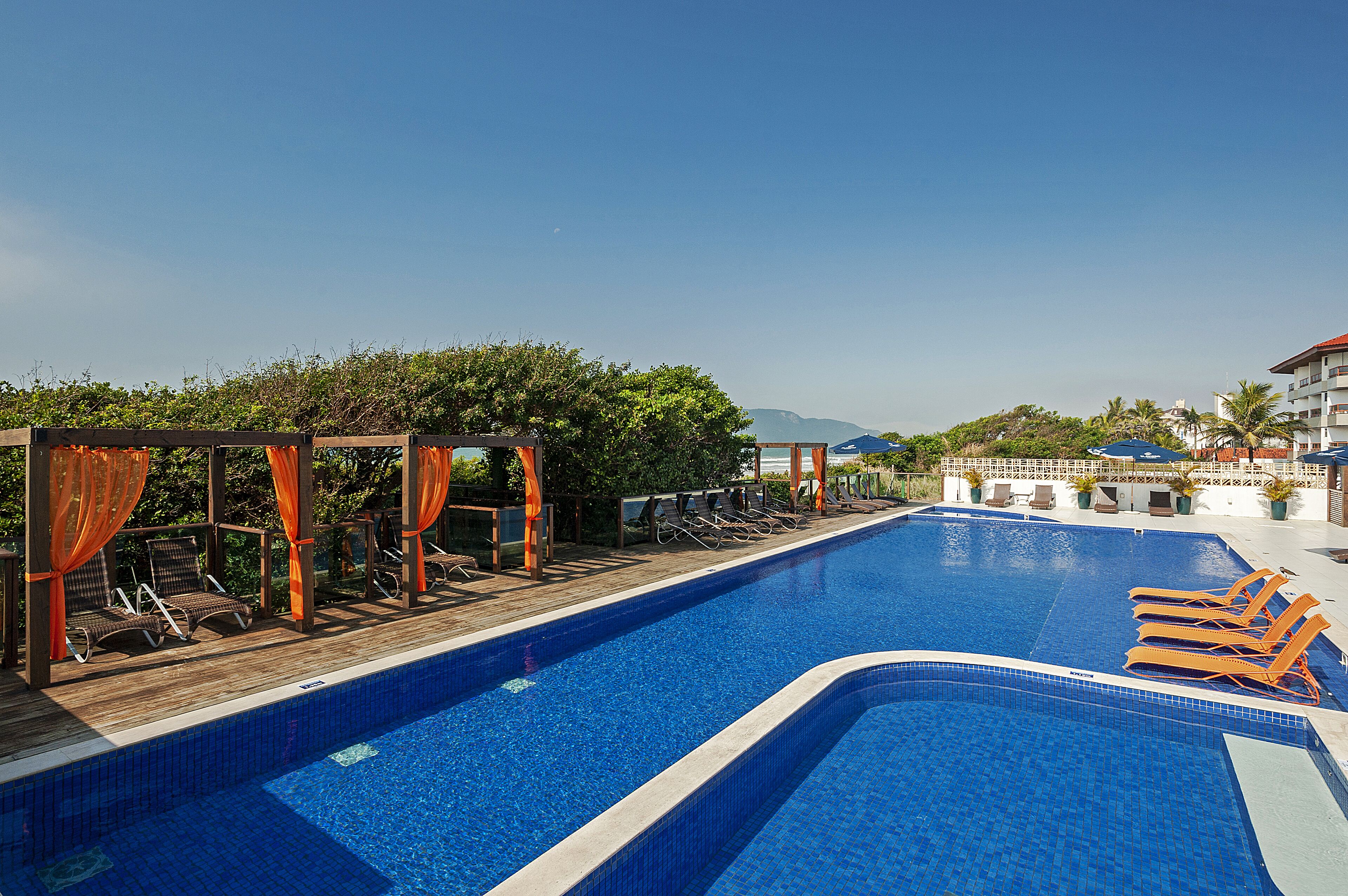 A swimming pool with lounge chairs and a wooden deck.