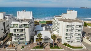 A modern hotel with multiple floors, balconies, and a view of the ocean. - SLAVIERO  Ingleses Convention (Florianópolis)