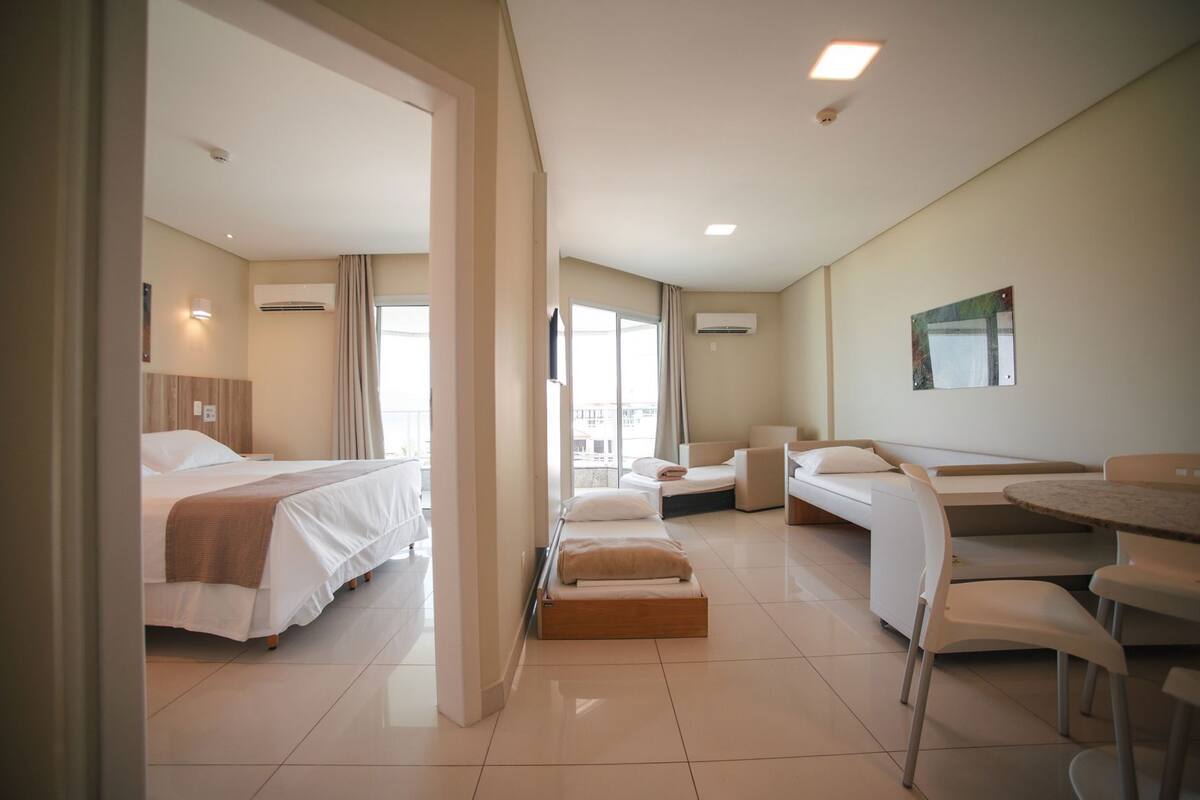 A hotel room with a bed, a sofa, a desk, and a chair.