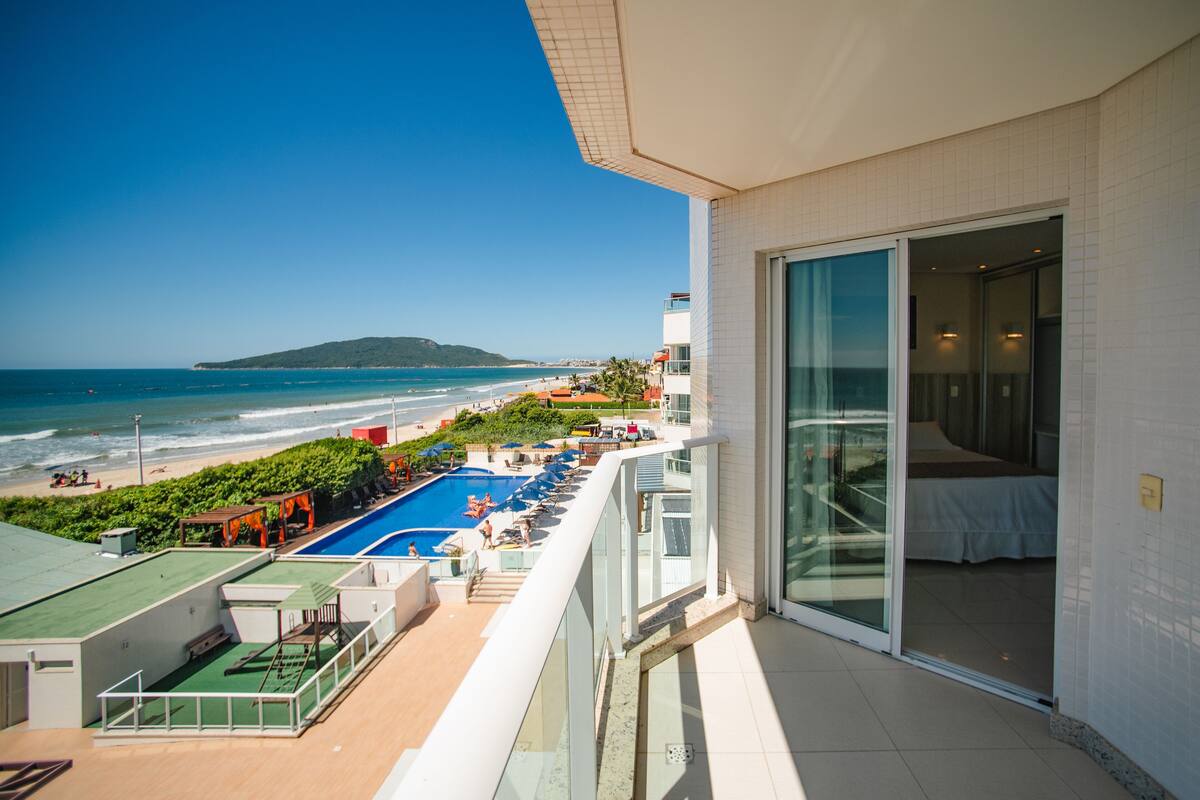 A balcony with a view of a beach and ocean.